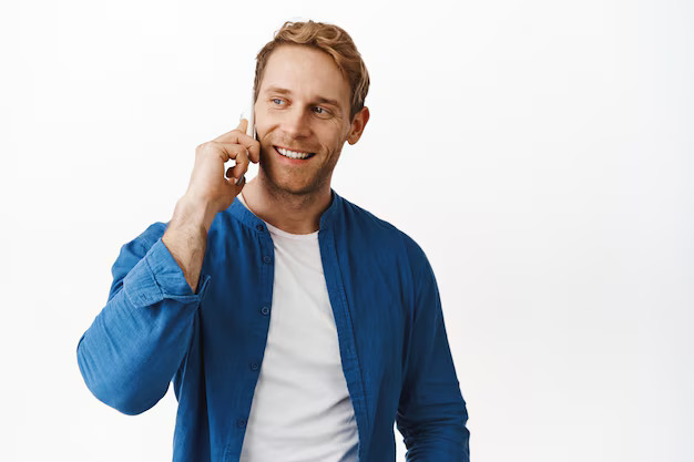 handsome-modern-redhead-man-talking-phone-calling-friend-smiling-holding-smartphone-near-ear-looking-aside-standing-against-white-background_176420-44914